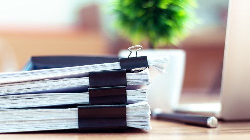 Stack of tender documents on a desk