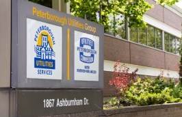 Peterborough Utilities sign with logos outside of office building 