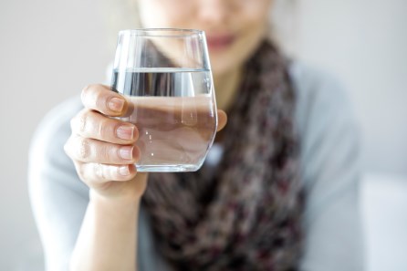 Woman holding glass of water